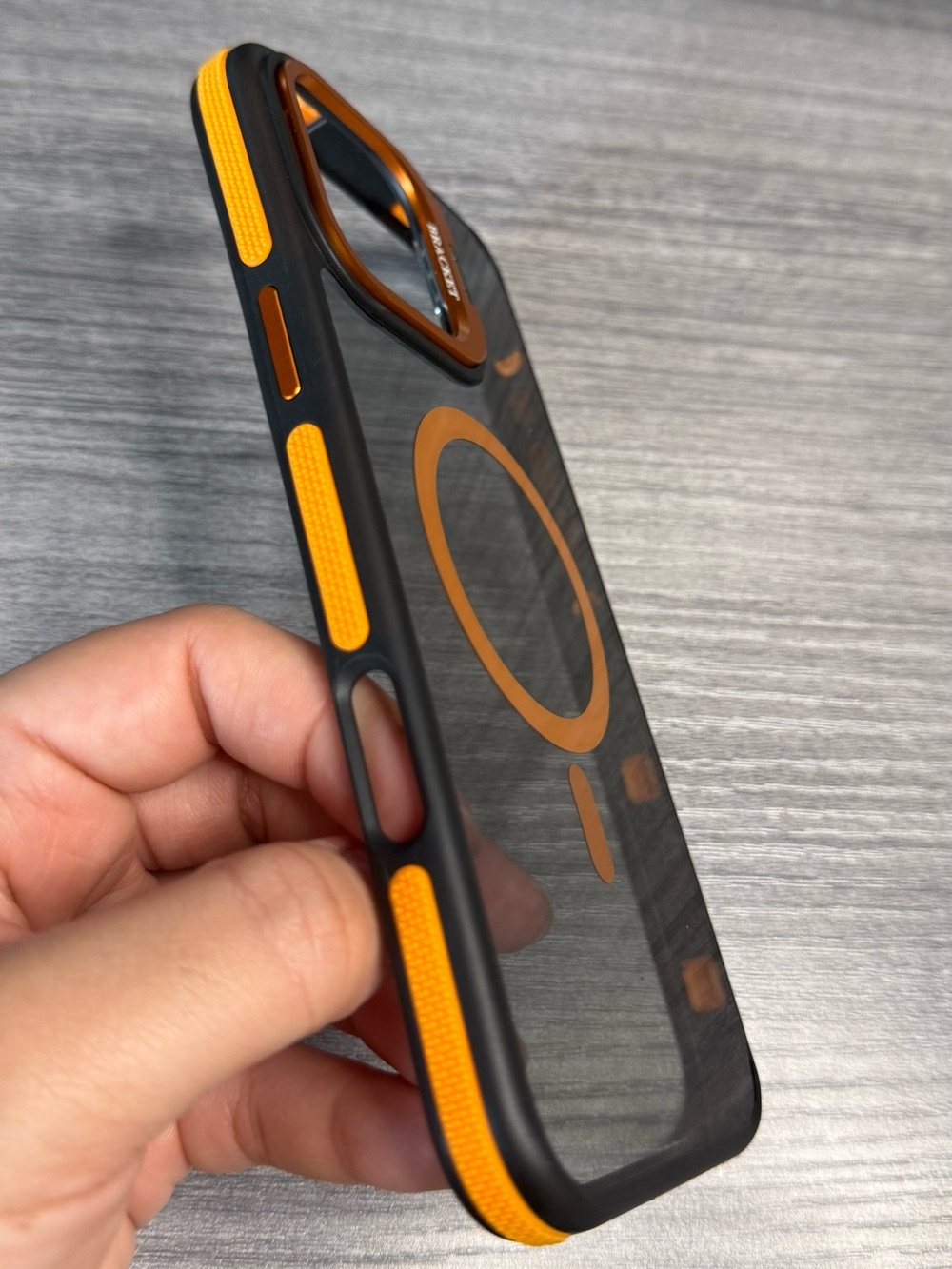 Transparent iPhone 16 Pro Max case, orange and black, MagSafe compatible.